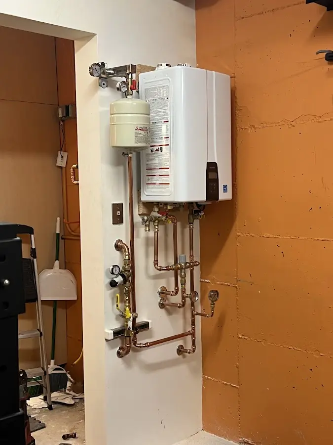 Plumbing technician inspecting water heater connections in Rib Mountain